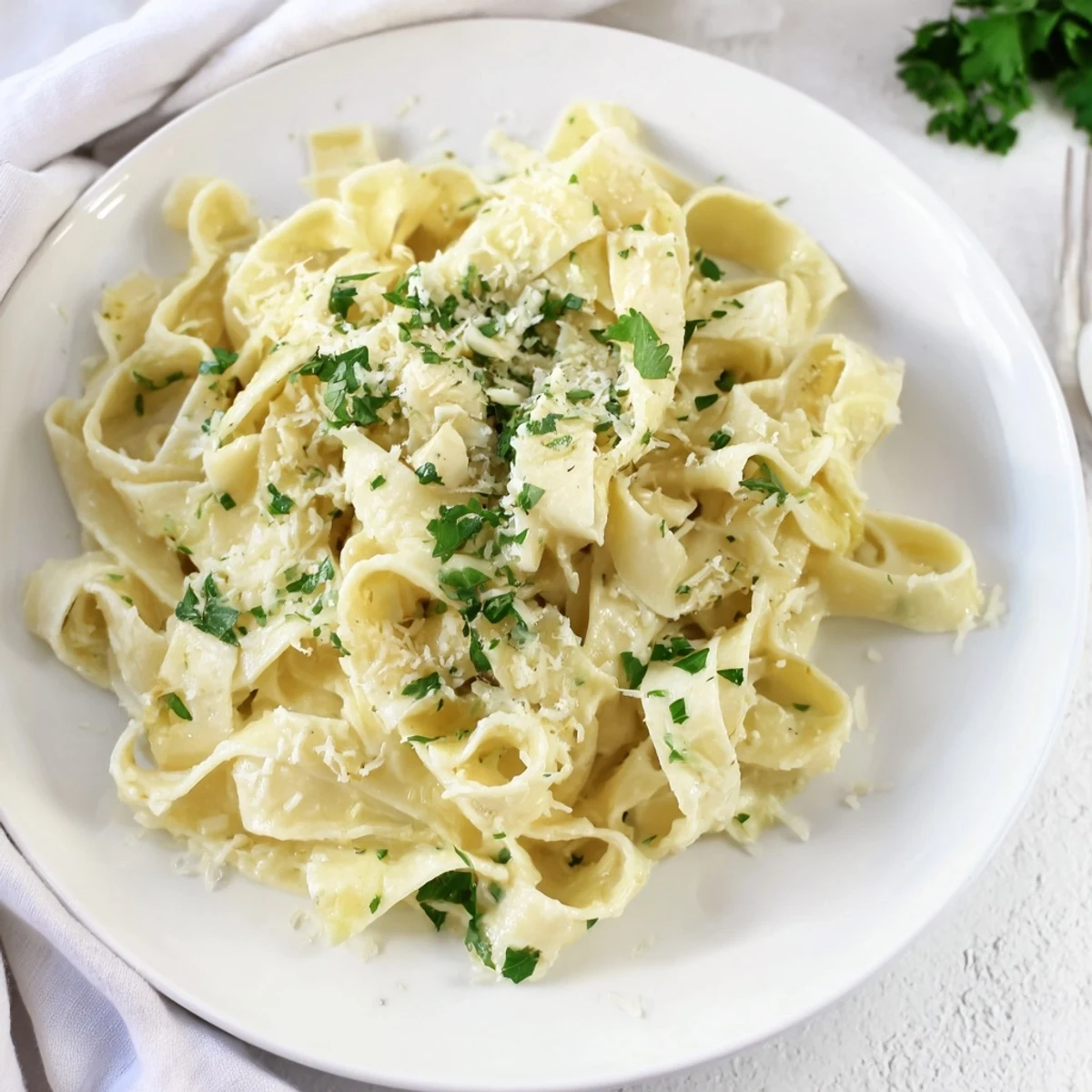 Quick 20-Minute Creamy Alfredo Pasta, a close-up of the dish garnished with fresh parsley and cheese.