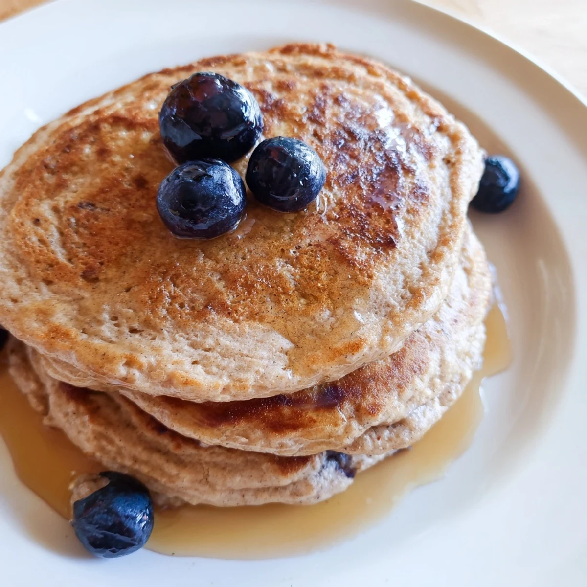 Golden-brown Protein Banana Pancakes, served with fresh berries, perfect for a healthy breakfast.
