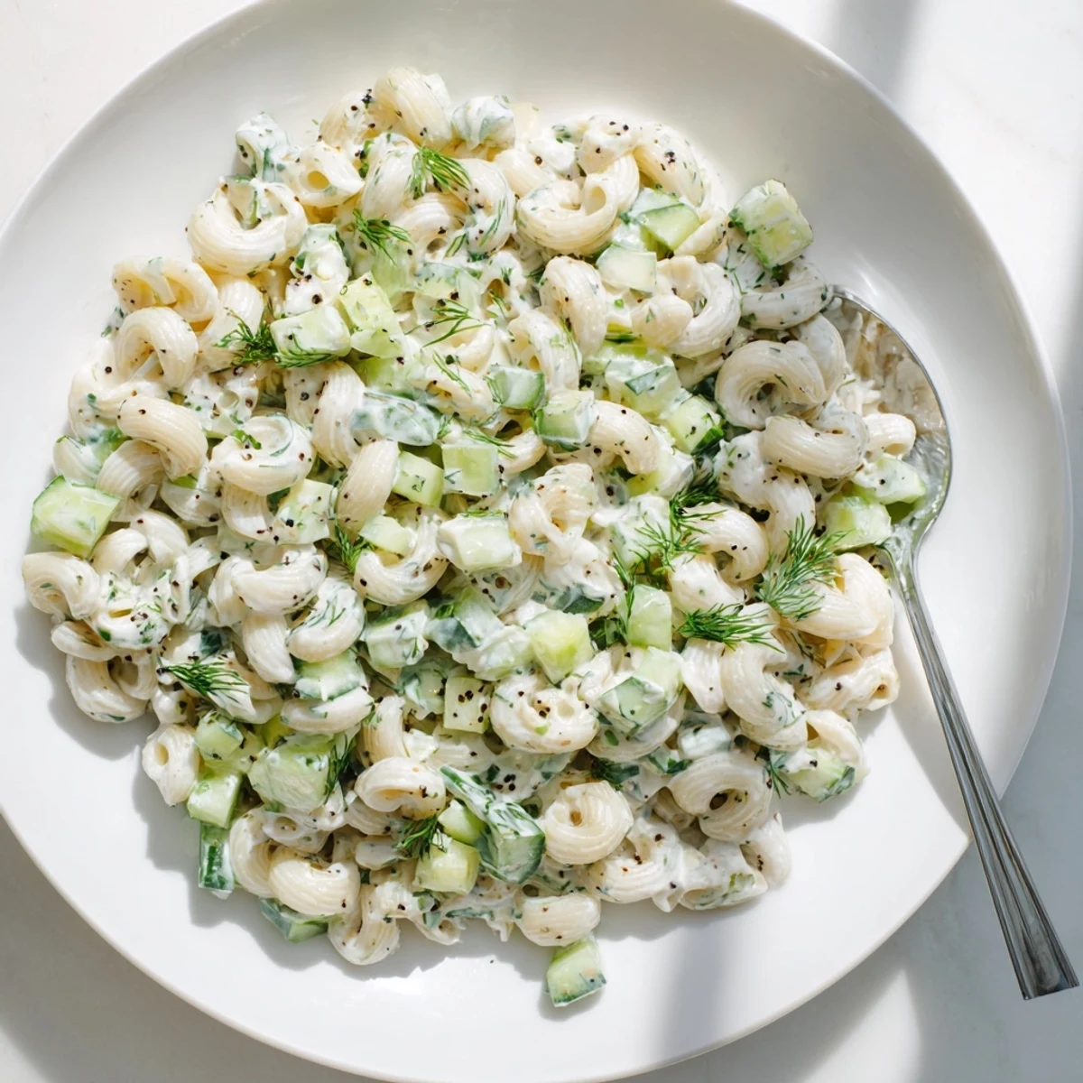 Cold small shell pasta tossed with crisp diced cucumbers, green onions, and fresh dill in tangy dressing.