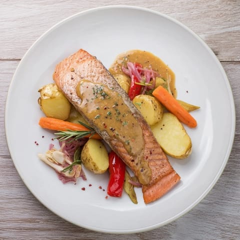 Tender salmon fillets coated in honey mustard sauce atop a tray of colorful veggies, a quick One-Tray meal.
