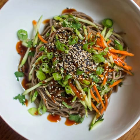 Flavorful chilled noodle lunch cups, tossed in shimmering sesame sauce, ideal for a picnic.