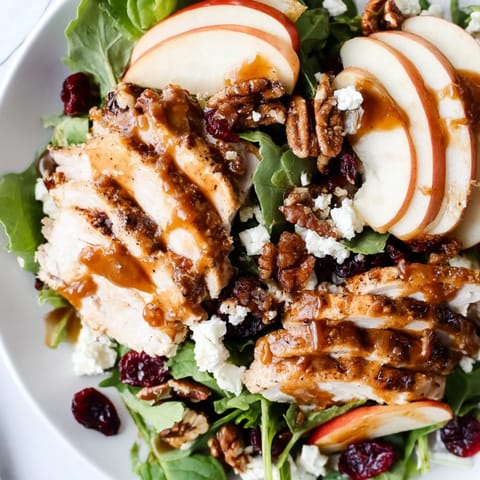 Autumn-inspired caramel apple chicken salad featuring tender chicken, crisp apples, feta, and candied pecans on fresh greens.
