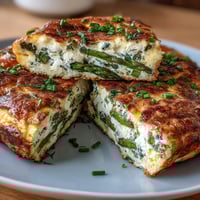 Spring Brunch Frittata with Asparagus and Goat Cheese: A golden, herb-flecked frittata baked to perfection with tender asparagus and creamy goat cheese.